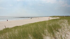 A beach with a dune, a few people, and a clear sky. - Nice home in Blåvand with sauna (Blåvand)