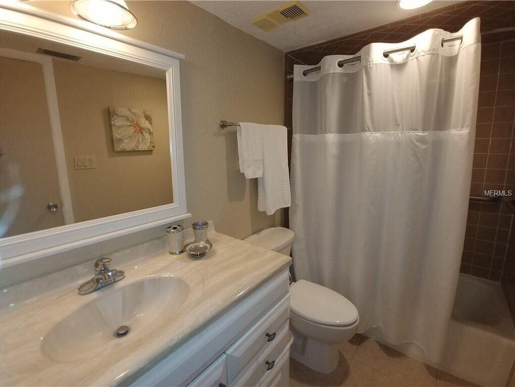 A bathroom with a sink, mirror, and toilet.