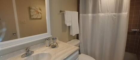 A bathroom with a sink, mirror, and toilet.