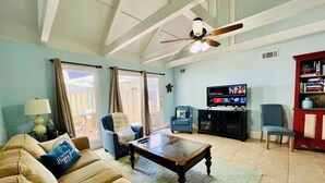 A living room with a sofa, armchairs, a coffee table, a television, and a bookshelf. - Best Queens Grant location: easy walk to all amenities.   (Hilton Head Island)