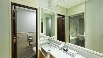 Un baño moderno con un espejo grande, un lavabo y una zona de ducha.