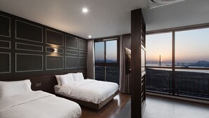 A modern hotel room with two beds, a large window with a city view, and a balcony with a railing. - Notte La Mia (Busan)