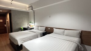 Ein Hotelzimmer mit zwei Betten, einem hölzernen Kopfteil, einem Nachttisch und einer Deckenleuchte.
