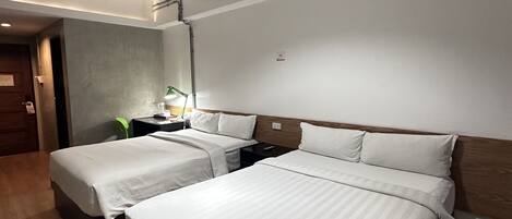 Una camera d'albergo con due letti, una testiera in legno, un comodino e un lampadario.