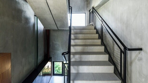 Eine Betonstairtreppe mit Metallgeländern, die zu einer oberen Etage führt.
