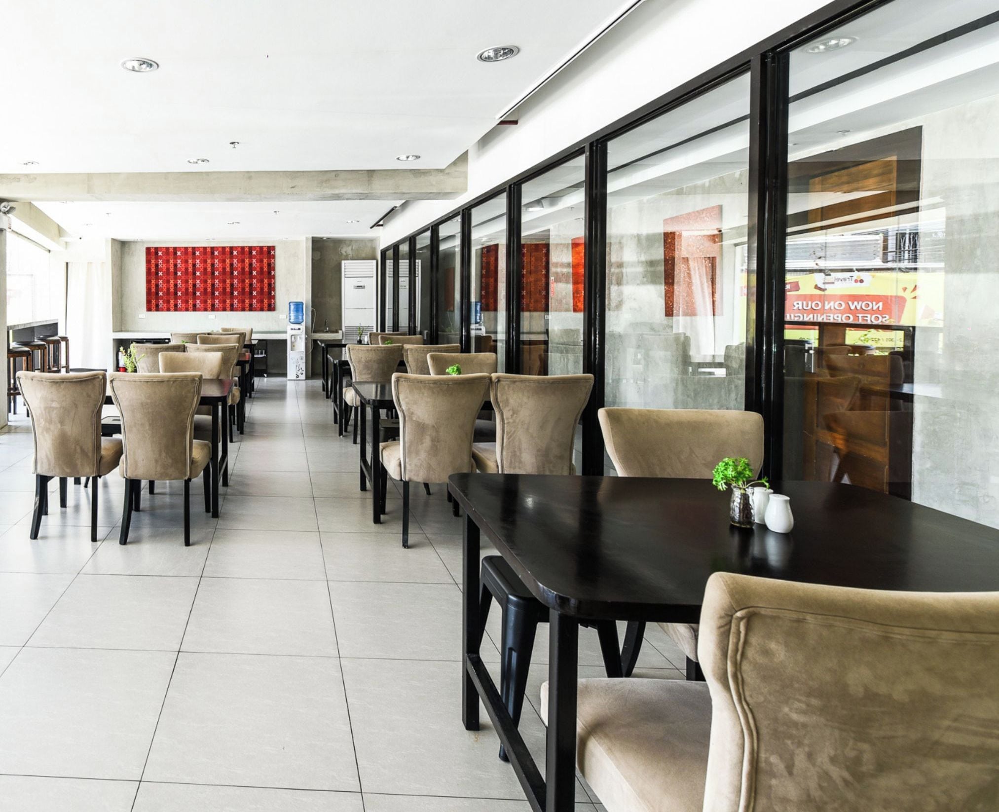 A spacious business inn with modern furnishings, including leather chairs and tables, and large windows offering views of the city.