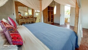 Ein Schlafzimmer mit einem großen Bett, einer Holzkommode, einem Spiegel und einem Kleiderschrank.