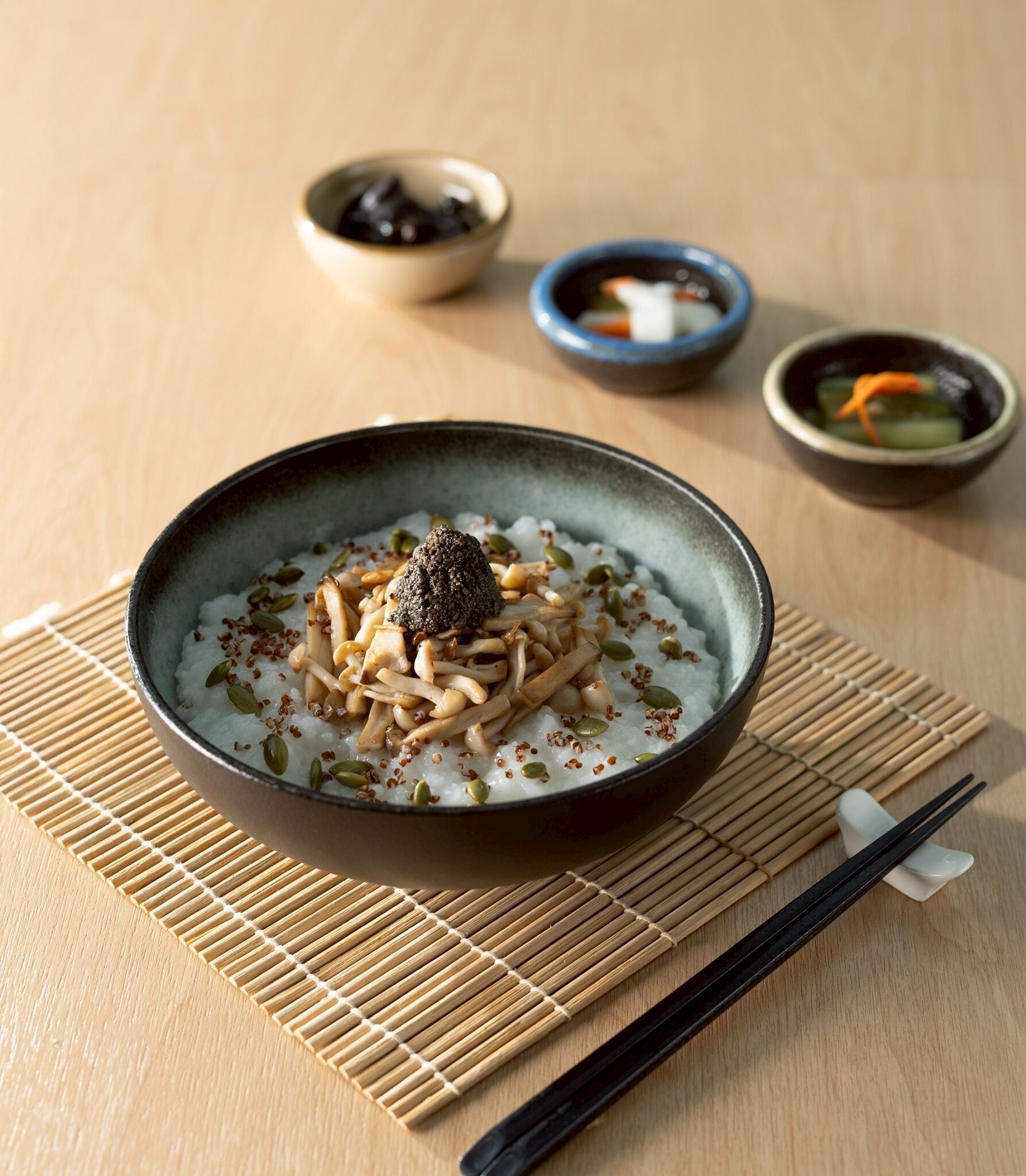 A bowl of rice with toppings on a bamboo mat.
