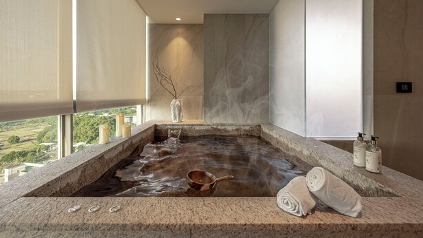 Et spaområde med jacuzzi, håndklæder og toiletartikler.