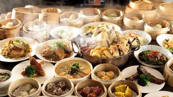 A variety of dishes in bamboo steamers and on plates, suggesting a diverse meal selection.