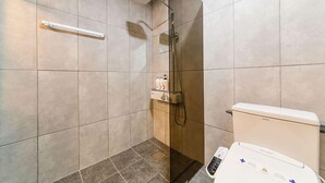 Ein modernes Badezimmer mit Dusche, Toilette und Bedienfeld.