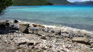 A rocky beach with clear turquoise water and green hills in the background. - AMAZING Westin St John!!  3 BD/3 BA Villa (Great Cruz Bay)