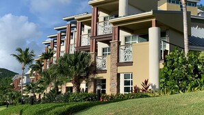 A multi-story hotel with balconies, palm trees, and a well-maintained garden. - AMAZING Westin St John!!  3 BD/3 BA Villa (Great Cruz Bay)