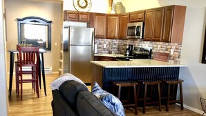 Una cocina moderna con armarios de madera, un refrigerador de acero inoxidable y un microondas integrado.