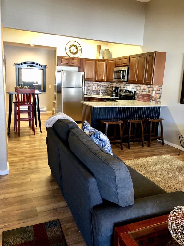 A modern kitchen with wooden cabinets, a stainless steel refrigerator, and a built-in microwave.