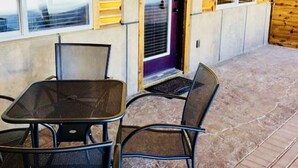 Una cabaña de madera con un patio que tiene una mesa y sillas.