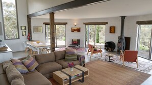 Amplia sala de estar con un sofá grande, una mesa de comedor y una chimenea.