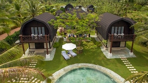 A resort with two large villas, a swimming pool, and lush tropical surroundings.