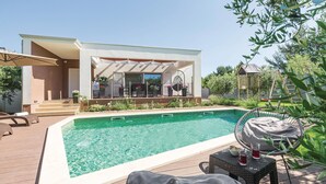 A swimming pool with lounge chairs and a covered patio area. - Gorgeous home in Pomer (Pomer)