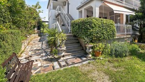 Una escalera de piedra que lleva a un edificio blanco con balcón.
