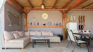 Un salon chaleureux avec un canapé beige, une petite table et un plafond en bois.