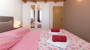 Une chambre à coucher avec un lit, une armoire, une porte et une table de chevet avec une lampe.
