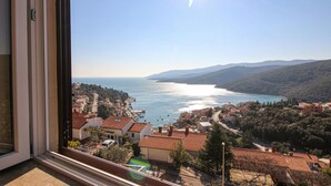 Uma vila costeira com vista para o mar e montanhas.