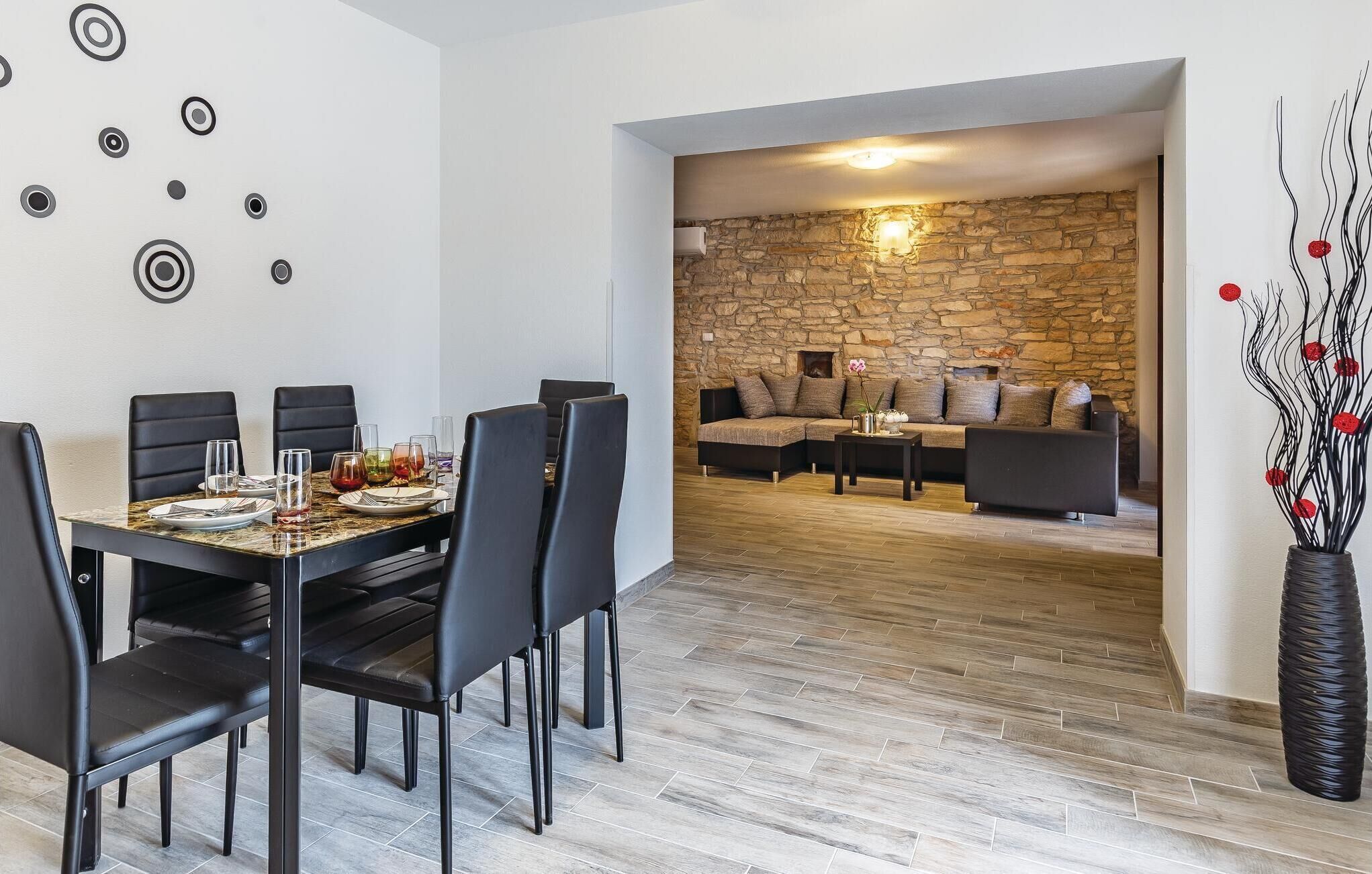 Un coin repas avec un mur en pierre et un canapé en arrière-plan.