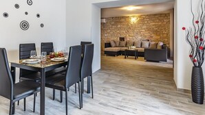 A dining area with a stone wall and a sofa in the background. - Awesome home in Peruski with WiFi (Peruski)