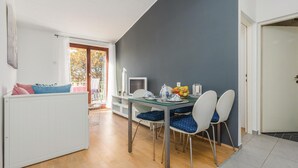 A dining area with a table set for two, a television, and a view of the outdoors. - 1 bedroom beach front apartment in Porec (Porec)