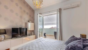 A bedroom with a bed, a TV, a desk, and a balcony with a view. - 2 bedroom pet friendly apartment in Selce (Selce)