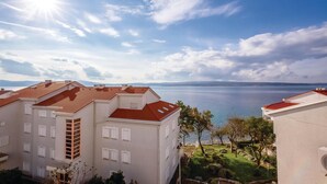 A residential building with a red-tiled roof overlooking a body of water. - 2 bedroom pet friendly apartment in Selce (Selce)
