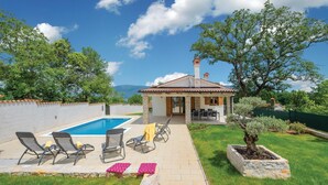 Una vila amb piscina, zona d'estar a l'exterior i vistes a les muntanyes.