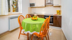 A compact kitchen with a dining table, chairs, a microwave, a stove, and a coffee maker. - Gorgeous apartment in Rabac with WiFi (Rabac)