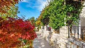 A stone wall with a metal railing, a clear sky, and a pathway. - Gorgeous apartment in Rabac with WiFi (Rabac)
