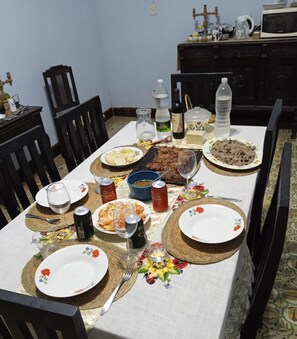 A beautifully set table awaits, complete with a roasted meat centerpiece, potatoes, and a fresh salad.