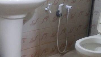 A bathroom with a white sink, a toilet, and a shower.