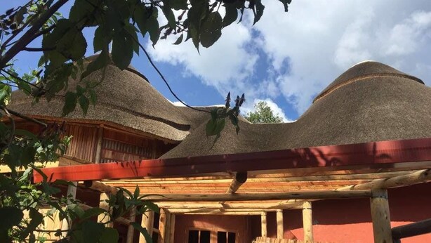 A traditional wooden building with a thatched roof and a wooden door. - Ingagi Park View Lodge (Kinigi)