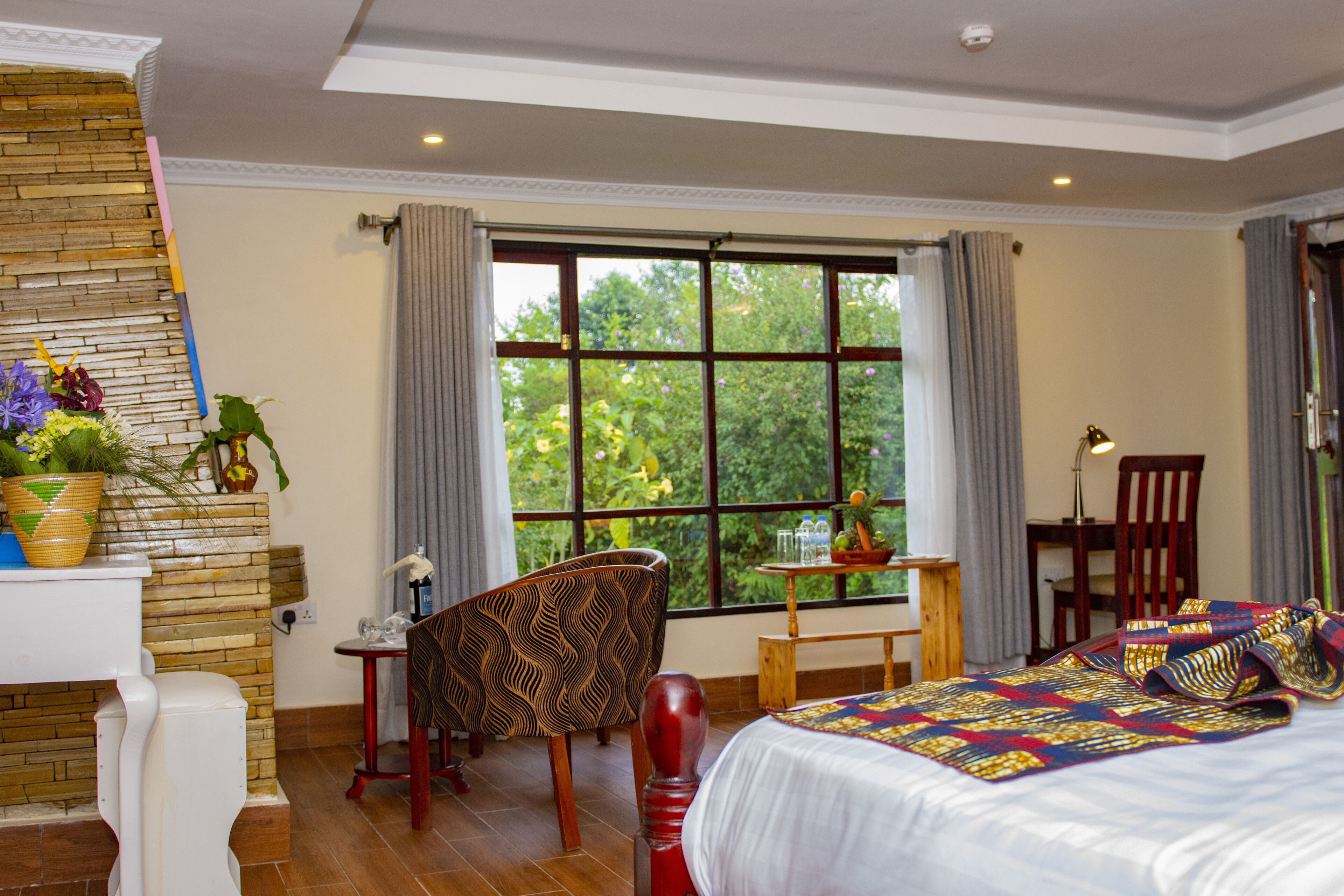 Una habitación de hotel con un ventanal grande, una cama, un escritorio y una silla.