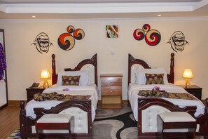 Una habitación de hotel con dos camas, una mesita de noche con lámpara y decoración en la pared.