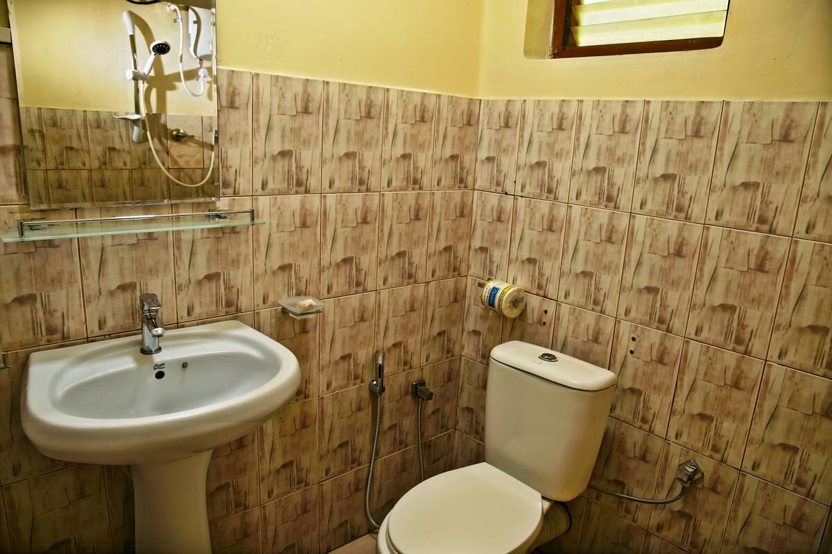 Un bany amb un lavabo, vàter i plat de dutxa.