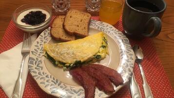 A breakfast plate with eggs, bacon, toast, and jam.