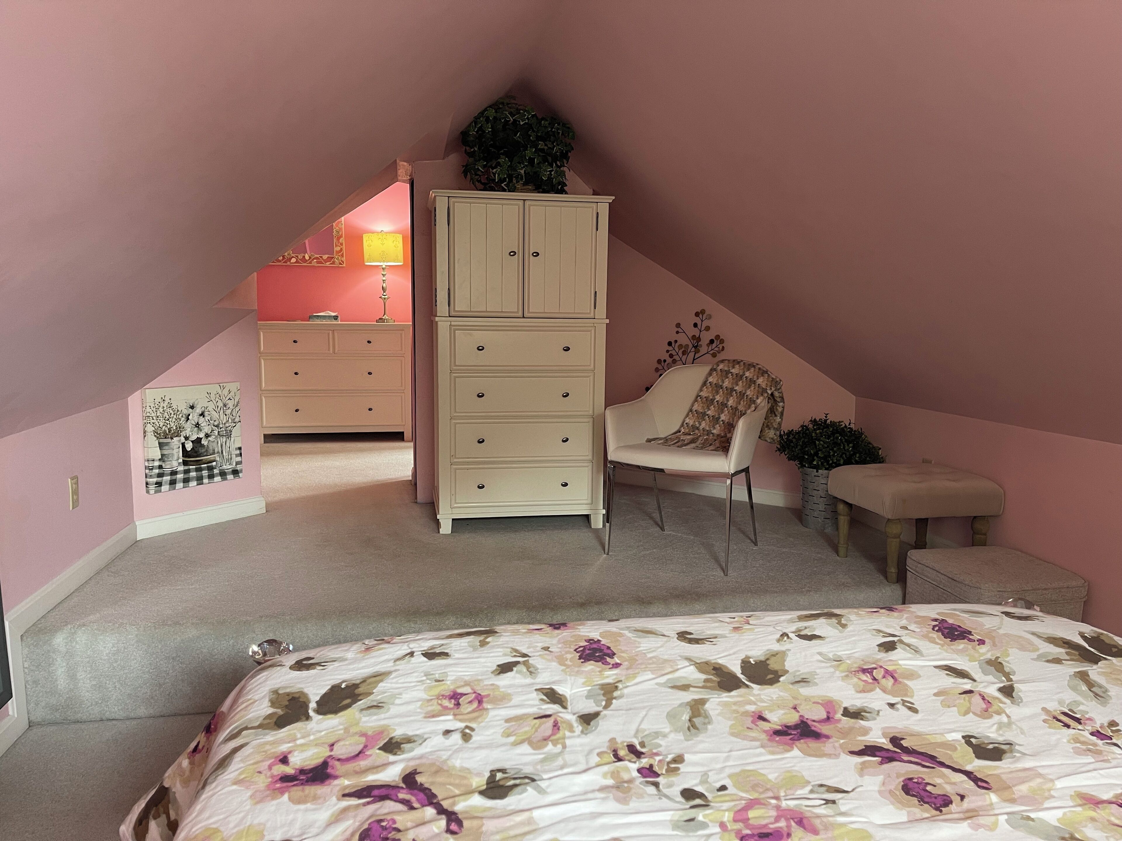 A bedroom with a bed, a dresser, a chair, and a small table.