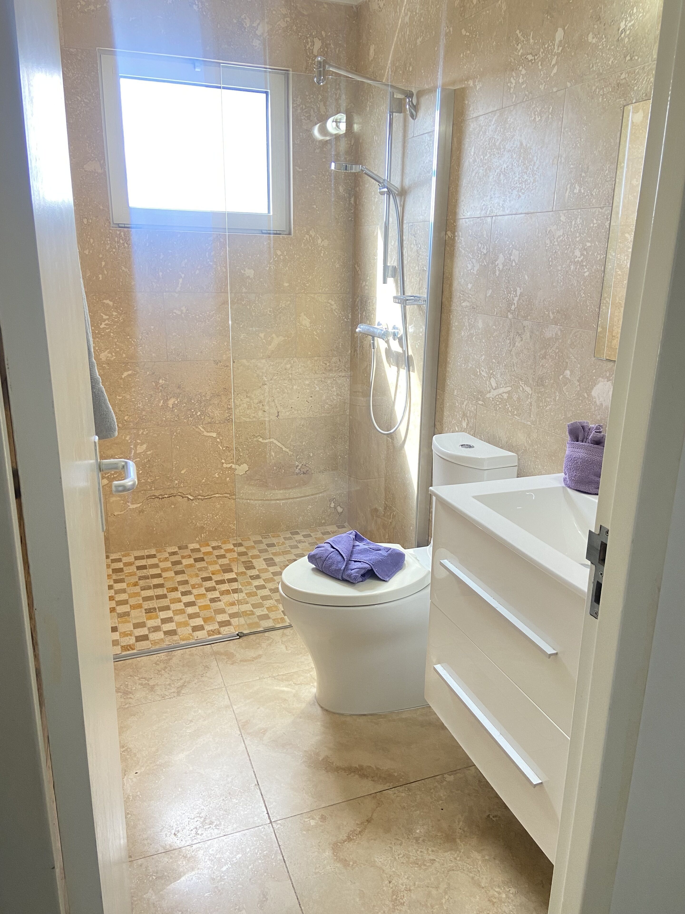 A bathroom with a shower, toilet, and sink.