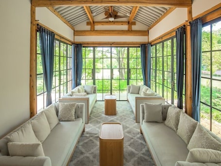 A room with a large window, a ceiling fan, and a sofa set.. Hangzhou Alor Valley