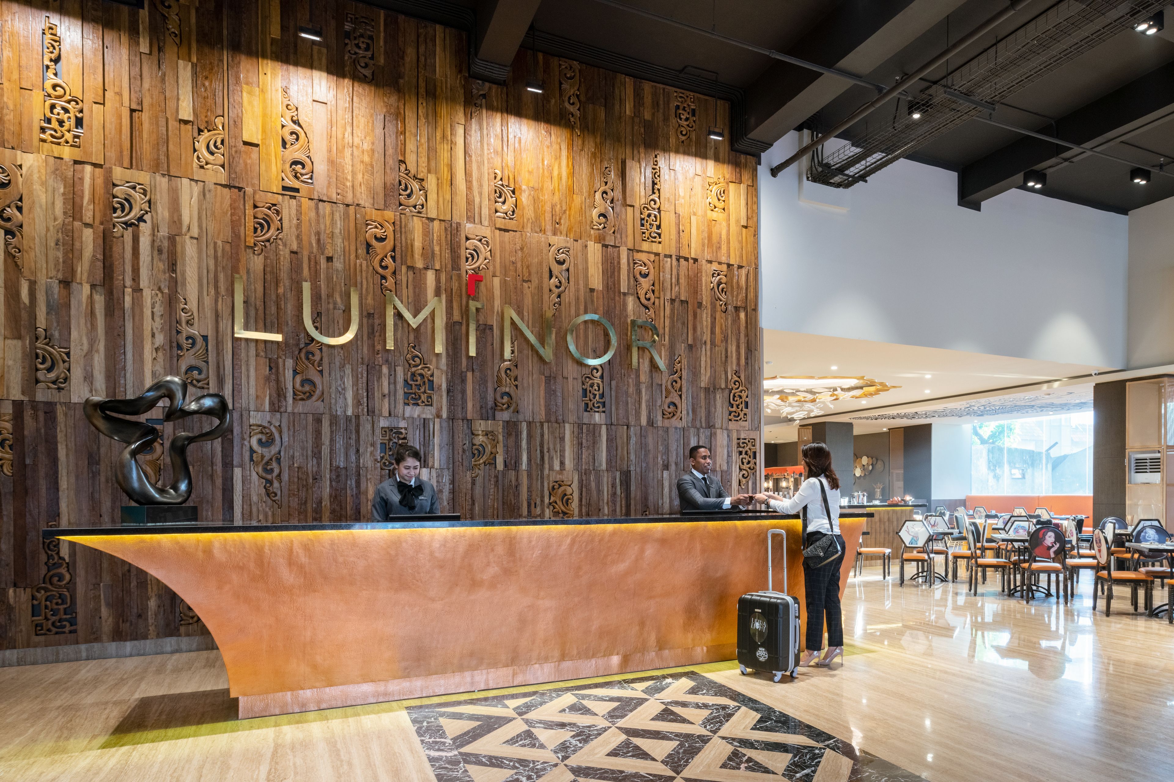 A reception area with a wooden wall displaying the name 'LUMINOR'.