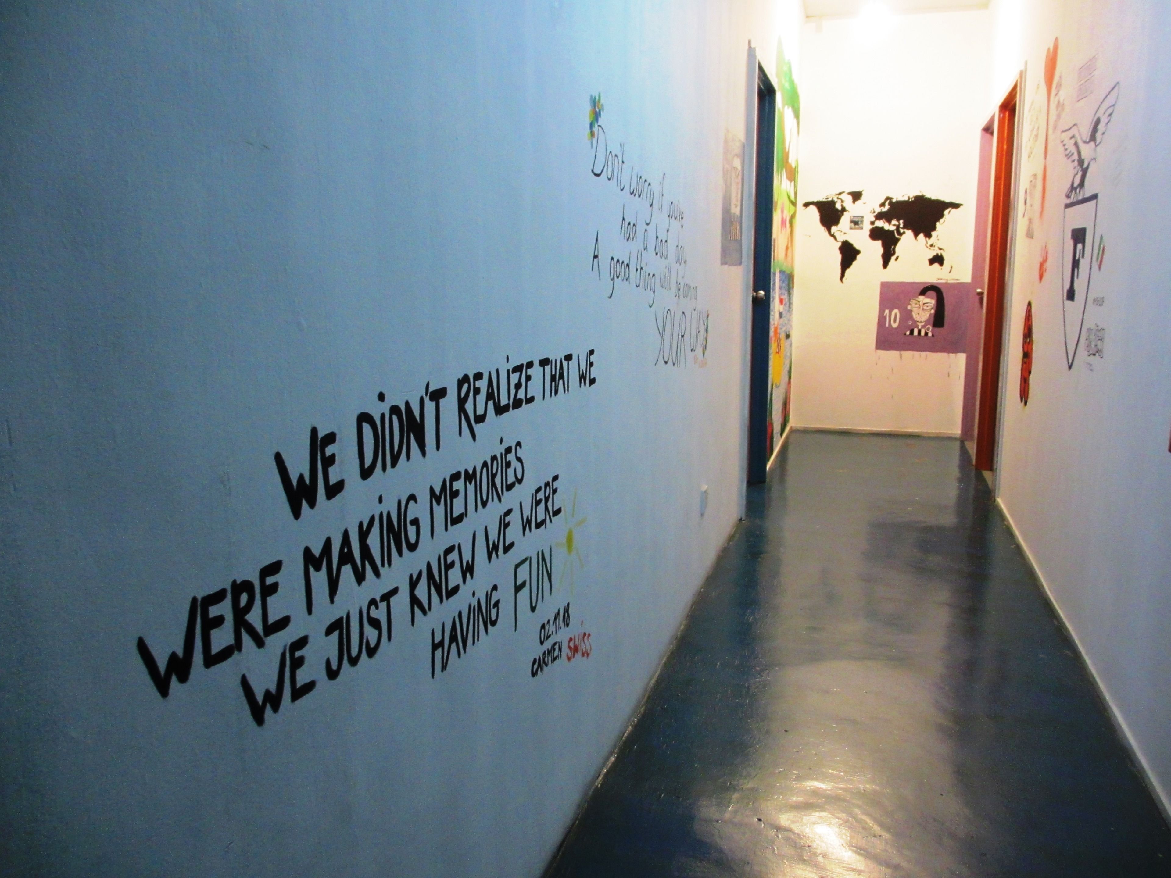 A hallway with motivational quotes and a world map on the wall.