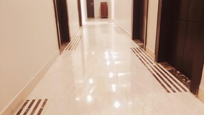 A corridor with a shiny, reflective floor and dark walls. - Hotel Ozas Grand (Varanasi)