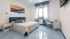 A modern bedroom with a bed, a desk, and a TV. - VIAPARSANO - two bedrooms flat (Sorrento)