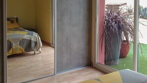 A room with a bed, a sliding glass door leading to a balcony with a potted plant. - Gorgeous home in Creissan (Creissan)